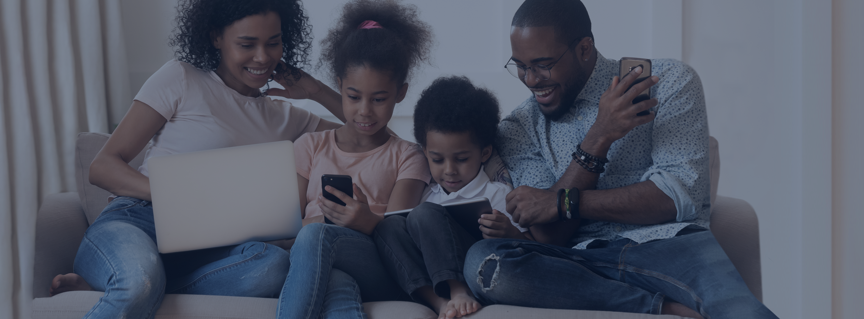 Family gathered around tech and tablets on a couch - Parent Portal Header
